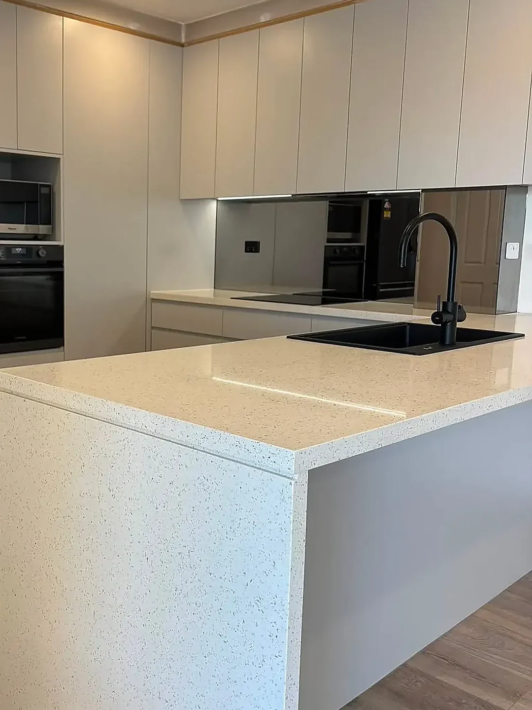 Kitchen island with waterfall return and black tapware